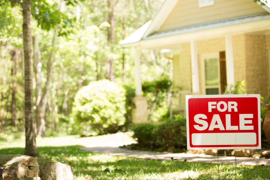 Home for sale with real estate sign.